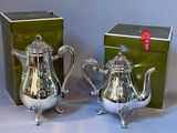 pair of silver plated teapots with matching box on table