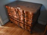 a wooden chest of drawers in the corner of a room