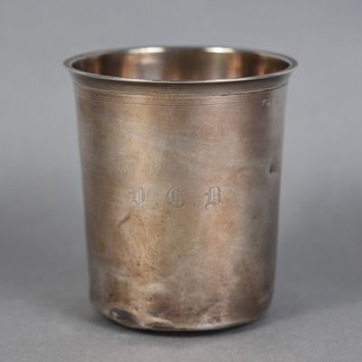 a close up of a silver cup on a gray surface