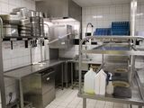 une cuisine avec de nombreux plans de travail en inox