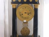 une horloge noire et dorée sous un dôme en verre