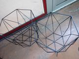 two black wire baskets sitting on the floor next to a door