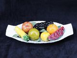 une assiette blanche avec des fruits dessus, sur fond noir