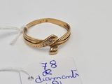 a gold ring with a diamond on it next to a price tag