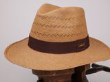 un chapeau marron posé sur une chaise en bois