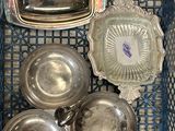 beaucoup de plats en argent dans un panier posé sur la table