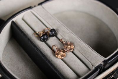 deux paires de boucles d'oreilles dans un écrin posé sur une table