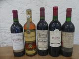 plusieurs bouteilles de vin sont alignées sur une table en bois