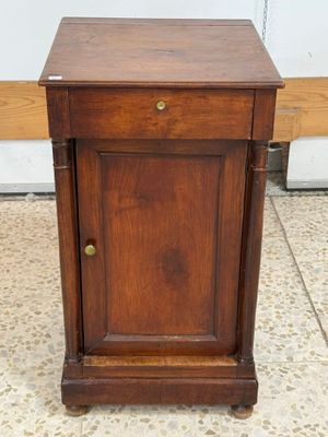 a small wooden cabinet on wheels on the floor