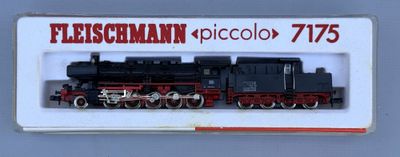 a black and red train on display in a white box