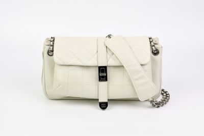 le petit sac blanc est posé sur une surface blanche