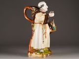 an image of a figurine of a monk holding a cup