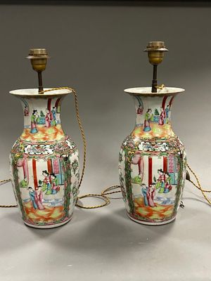 une paire de vases chinois ornés de scènes asiatiques, posés sur une table