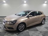 Une voiture beige est garée dans une pièce dont le sol est à carreaux.