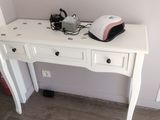a white desk with a phone and a lamp on it