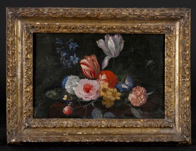 un tableau représentant des fleurs, dans un cadre doré, sur fond noir