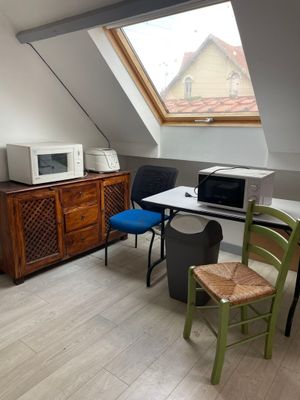 une photo d'une petite pièce avec un micro-ondes et une table