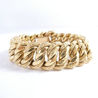 a close up of a gold bracelet on a white background