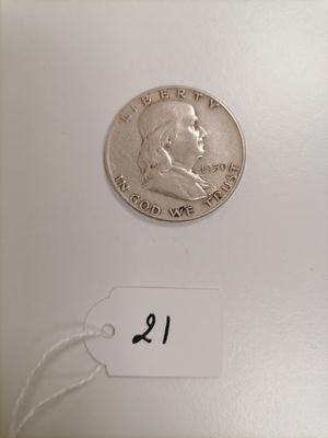 a close up of a coin on a white surface with a price tag