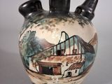 a vase with a picture of a house on it