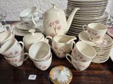 many cups and saucers and plates on the table