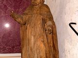 une statue représentant un homme tenant un parapluie dans un coin d'une pièce