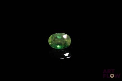 une pierre verte couleur émeraude sur un fond noir