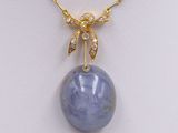 a blue jade and diamond pendant on a gold chain