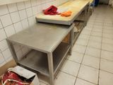 a kitchen with a table and a trash can on the floor