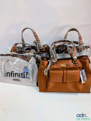 trois sacs contenant des sacs à main sont emballés dans du plastique sur une surface blanche