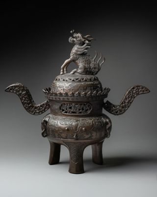an image of a bronze teapot with a dragon on top