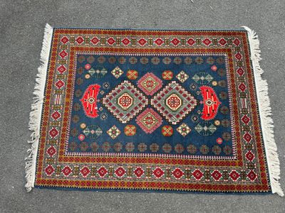 un gros plan d'un tapis posé sur une moquette, orné d'un motif rouge et bleu