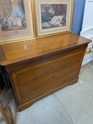 a dresser with two pictures on top of it