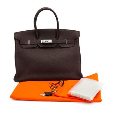 an orange and black handbag with an orange cloth and a black purse