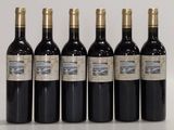 six bouteilles de vin sont alignées sur une table