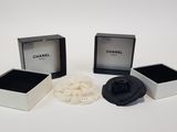 three black and white jewelry boxes with a flower in them