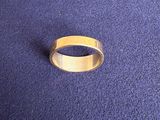a close up of a gold ring on a blue surface