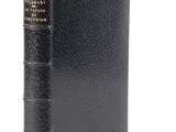 un livre noir à la reliure dorée et à la couverture noire