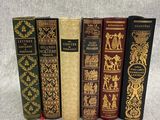 four books are lined up in a row on a table