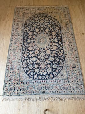un tapis bleu et blanc posé sur un parquet, à côté d'un chat
