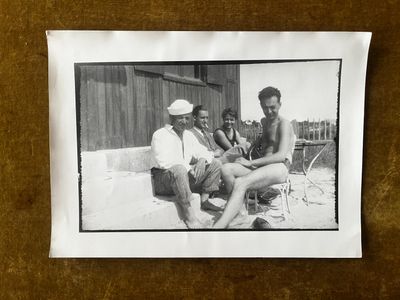 photographie en noir et blanc d'un groupe d'hommes assis autour d'une table