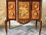 une petite commode sur laquelle est posée une horloge