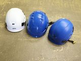 three hard hats are lined up on the floor next to each other