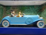 une petite voiture bleue avec un chien et un chat à l'intérieur