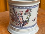 un vase blanc orné de fleurs bleues et rouges