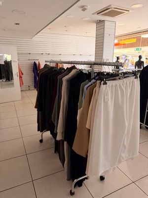 un portemanteau dans un magasin de vêtements, sur lequel sont suspendus des vêtements