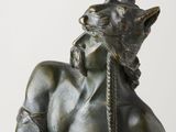 statue of a man with a cat on his head holding a knife