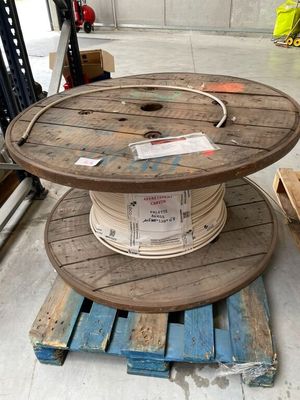 une bobine en bois posée sur une palette dans un entrepôt