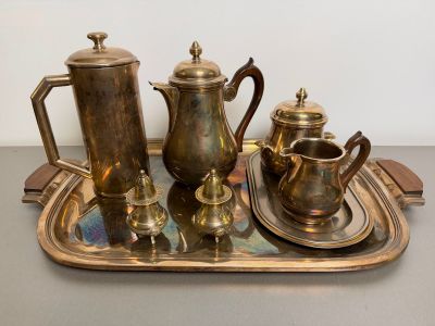 a tray that has a silver tea set on it