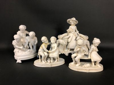 three white figurines of people sitting on a bench